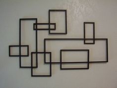 a metal wall sculpture with squares and rectangles