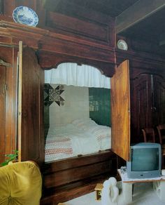 an old fashioned bedroom with a bed and tv