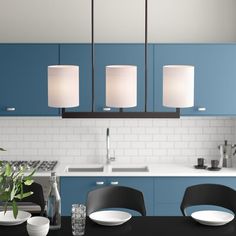 a modern kitchen with blue cabinets and white counter tops, black dining room chairs and an island in the middle