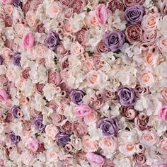 the wall is made up of many different colored flowers and has white, pink, purple, and red roses on it