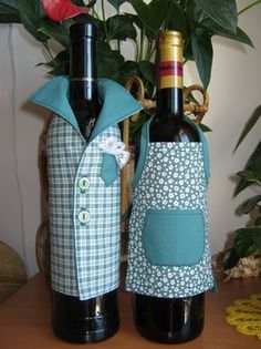 two wine bottles are sitting next to each other on a table with flowers in the background