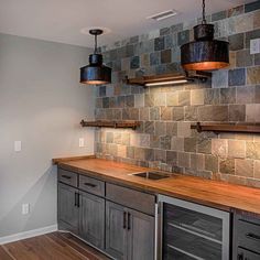 a kitchen with wooden counter tops and gray cabinets