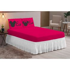 a bed with pink sheets and mickey mouse pillows