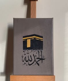 a painting on a easel with the word khuj written in black and gold