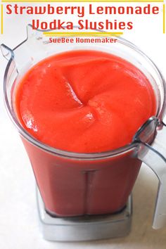 a blender filled with red liquid on top of a table