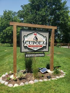 a sign for cupola in the middle of a field