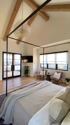 a large bed sitting inside of a bedroom on top of a hard wood floor