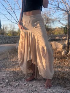 Fitted Beige Skirt For Festivals, Bohemian Baggy Cotton Skirt, Cotton Asymmetrical Skirt For Festival, Asymmetrical Cotton Skirt For Festival, Baggy Cotton Bohemian Skirt, Festival Belly Dance Skirt, Spring Bohemian Maxi Skirt With Asymmetrical Hem, Cotton Asymmetrical Skirt For Beach, Bohemian Maxi Skirt With Asymmetrical Hem For Spring