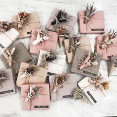 many wrapped gift boxes with ribbons and bows on them sitting on a marble counter top