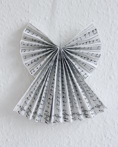 an ornament made out of sheet music notes hanging from a string on a wall