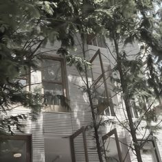 an apartment building with trees in the foreground and sunlight coming through the windows on the second floor