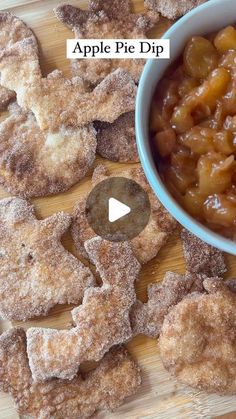 an apple pie dip is in a bowl with sugar on the side and apples next to it