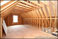 an attic with wooden walls and exposed rafters on the ceiling is being built in