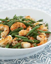 a white bowl filled with green beans and shrimp