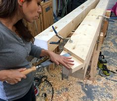 a woman is working on some wood