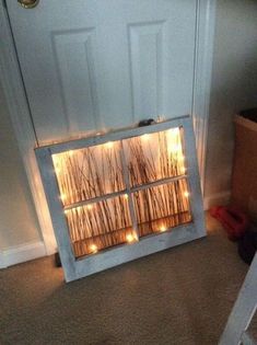 an open window with some lights in it on the floor next to a white door