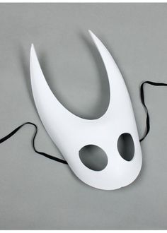 a white mask with black holes on it