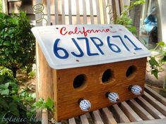 a wooden birdhouse with the word california written on it's side and holes in the roof