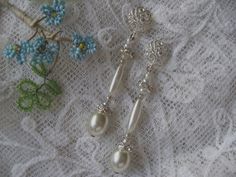 PEARLS AND FAUX DIAMANTE WEDDING EARRINGS A combination of super lustrous, delicate, antique faux pearl earrings which would  complement any bride on her wedding day. Just a touch of diamante, combined with vintage  pearls. The pearls vary in shape and size, which makes this lovely pair of earrings so interesting.  These earrings are for pierced ears and have satin finish silver scrolls and rose shaped posts. The length of these chic earrings is 5 cm  The earposts are silver. Faux Pearl Earrings, Chic Earrings, Enamel Earrings, Antique Earrings, Vintage Pearls, Glass Earrings, Blue Earrings, Wedding Earrings, Turquoise Stone