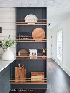 the shelves in this kitchen are organized with wooden cutting boards and other utensils