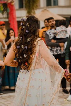 a woman in a wedding dress walking down the street