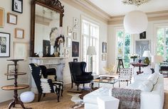 a living room filled with furniture and pictures on the wall next to a fire place