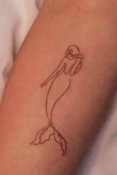 a small mermaid tattoo on the arm