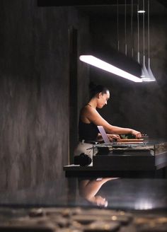 a woman sitting at a table in front of a laptop on top of a counter