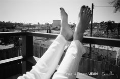 a person with their feet up in the air on top of a wooden deck overlooking a city