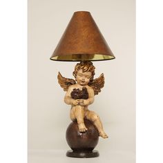 a lamp that is sitting on top of a ball with an angel figurine