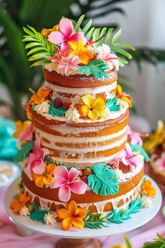 a multi layer cake decorated with flowers and leaves on a pink tableclothed table