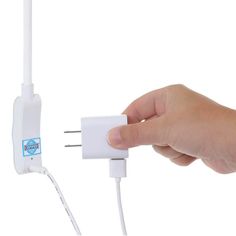 a hand is plugging in to a wall charger