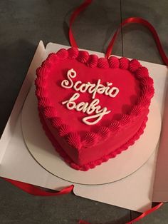 a heart - shaped cake with the words scorcia baby on it sits in a box