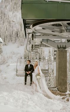 a bride and groom sitting on a chairlift in the snow at a ski resort