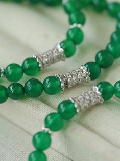 This elastic necklace combines traditional Chinese aesthetic elements with modern style. Featuring sparkling zirconia beads and soothing green agate beads, this necklace exudes elegance and sophistication. The intricate bead arrangement creates a harmonious balance between vintage charm and modern style. Metal: Recycled Sterling Silver Gemstone: Cubic Zirconia,Green Onyx Diameter: Long 760mm,Short 440mm Weight: Long 42g,Short 24g Elegant Jade Crystal Necklaces With Round Beads, Elegant Beaded Jade Crystal Necklaces, Elegant Jade Crystal Necklace With Round Beads, Elegant Beaded Jade Crystal Necklace, Elegant Jade Gemstone Beaded Bracelets, Elegant Jade Beaded Necklace With 8mm Beads, Elegant Green Bracelets With Silver Beads, Elegant Green Crystal Necklaces With Polished Beads, Elegant Rondelle Beads With Natural Stones