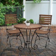 two wooden chairs and a table on a brick patio