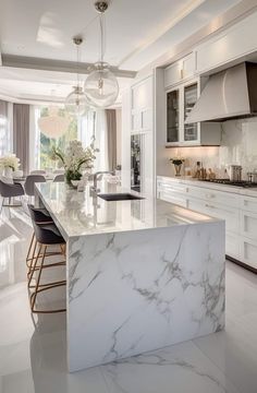 a large kitchen with marble counter tops and white cabinets, along with bar stools