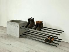 there are four pairs of shoes sitting on a bench in front of a white wall