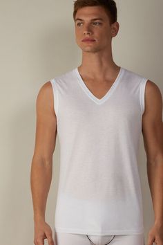 Sleeveless vest top with wide straps and a V-neck in 100% Extra-Fine SUPIMA® Cotton. Incredibly soft and breathable, this premium fiber offers excellent elasticity. The structure of the fabric means it will last wash after wash. A simple, comfortable style that's ideal for any occasion, whether worn as underwear or outerwear. White V-neck Top With Seamless Collar, Classic Cotton V-neck Tank Top, Cotton V-neck Tank Top For Loungewear, Classic V-neck Tank Top For Summer, Solid Cotton V-neck Tank Top, Cotton V-neck Tank Top, Solid Color Cotton V-neck Tank Top, Seamless Elastane V-neck Tank Top, Stretch Seamless V-neck Top