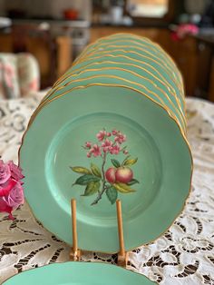 a table topped with green plates and pink flowers