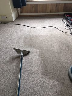 a vacuum is laying on the floor in front of a window with wires attached to it