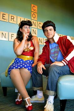 a man and woman dressed in costumes sitting next to each other on a blue chair