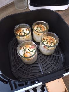 four glasses filled with food sitting on top of a grill