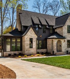 a large brick house with lots of windows on the front and side of it's roof