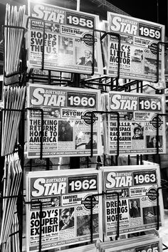 many newspapers are stacked on top of each other in this black and white photo,