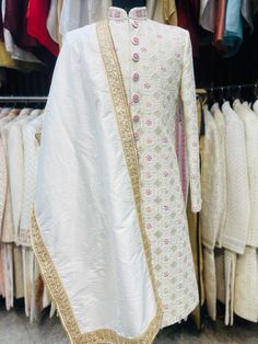 Item Contains :  Sherwani  Kurta  Pyjama and  Shoes Colours :  Greenish Ivory  Fabrics :  Pure silk premium fabric  Embroidery :  All over work over the sherwani is a mix of hand work zardosi and thread work which comprises of beads squares in the centre a flowers is highlighted with magenta and peach resham thread and round shaped beads and sequences and it's has all over cotton thread work too on back  Style and Design :  Sherwani has mandarin collar and long sleeves with a full button placket Bollywood Art Silk Sherwani With Chikankari Embroidery, Naqshi Embroidered Straight Kurta Sherwani For Reception, Naqshi Embroidered Straight Sherwani For Reception, Naqshi Embroidered Sherwani For Reception, Traditional Bandhgala With Chikankari Embroidery In Art Silk, Art Silk Sherwani With Chikankari Embroidery, Straight Kurta, Art Silk Sherwani With Chikankari Embroidery, Chikankari Embroidered Art Silk Sherwani, Diwali Raw Silk Sherwani With Chikankari Embroidery