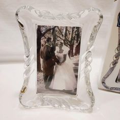 a glass photo frame with an image of a bride and groom in the background next to it