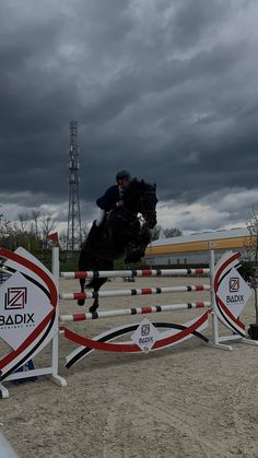 a person jumping a horse over an obstacle