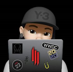 a person wearing a baseball cap is looking at a laptop with stickers on it