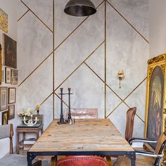 a dining room table with chairs and pictures on the wall